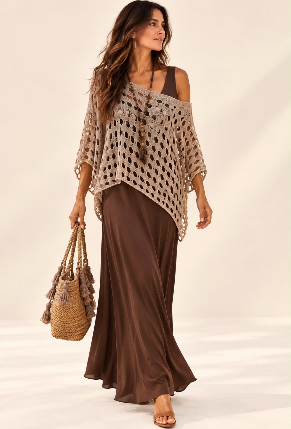 Pull crochet bohème beige ajouré porté sur une robe chocolat, coupe ample et bas asymétrique