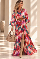 Robe Toscana longue à imprimé abstrait rose rouge et turquoise, col chemisier et jupe évasée, portée ceinturée
