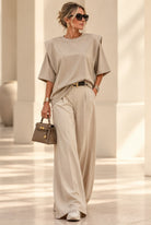 Top Elysée beige à épaules marquées, porté avec un pantalon clair