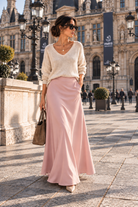 Jupe Poche rose longue et évasée avec poches latérales, portée avec un pull écru