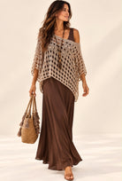 Pull crochet bohème beige ajouré porté sur une robe chocolat, coupe ample et bas asymétrique