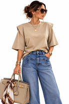 Top Elysée beige à épaules structurées et col rond, porté avec un jean